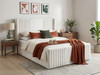The Pepita Ottoman Storage Bed finished in a warm cream velvet fabric. The contemporary design showcases deep channel tufting on the winged headboard and solid floor-length base